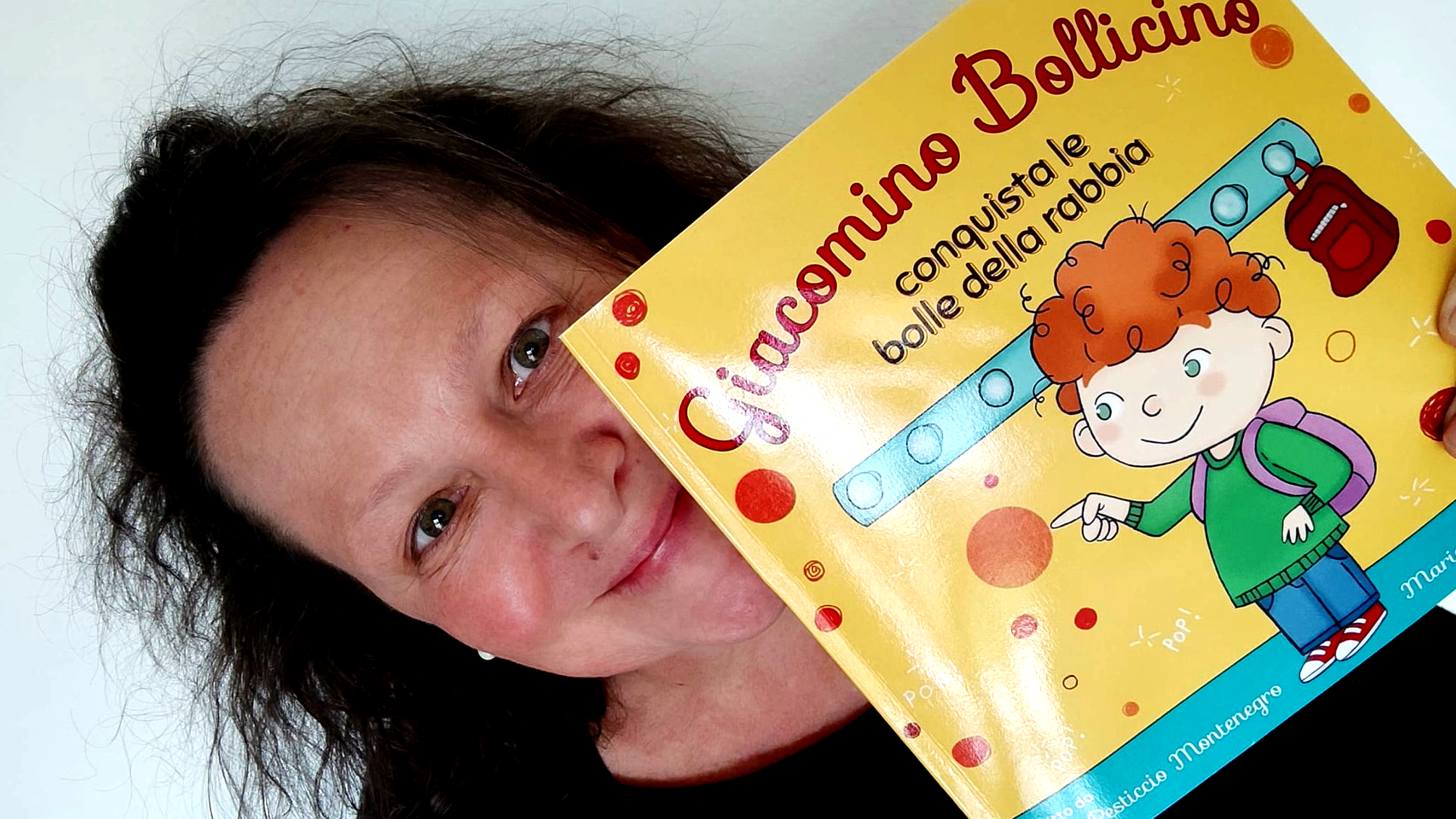 Guia che mostra la copertina del suo libro Giacomino Bollicino