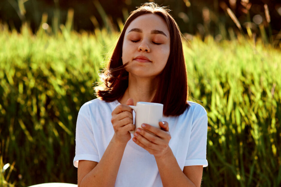Ragazza in un giardino che si ralassa bevendo un atazza di te