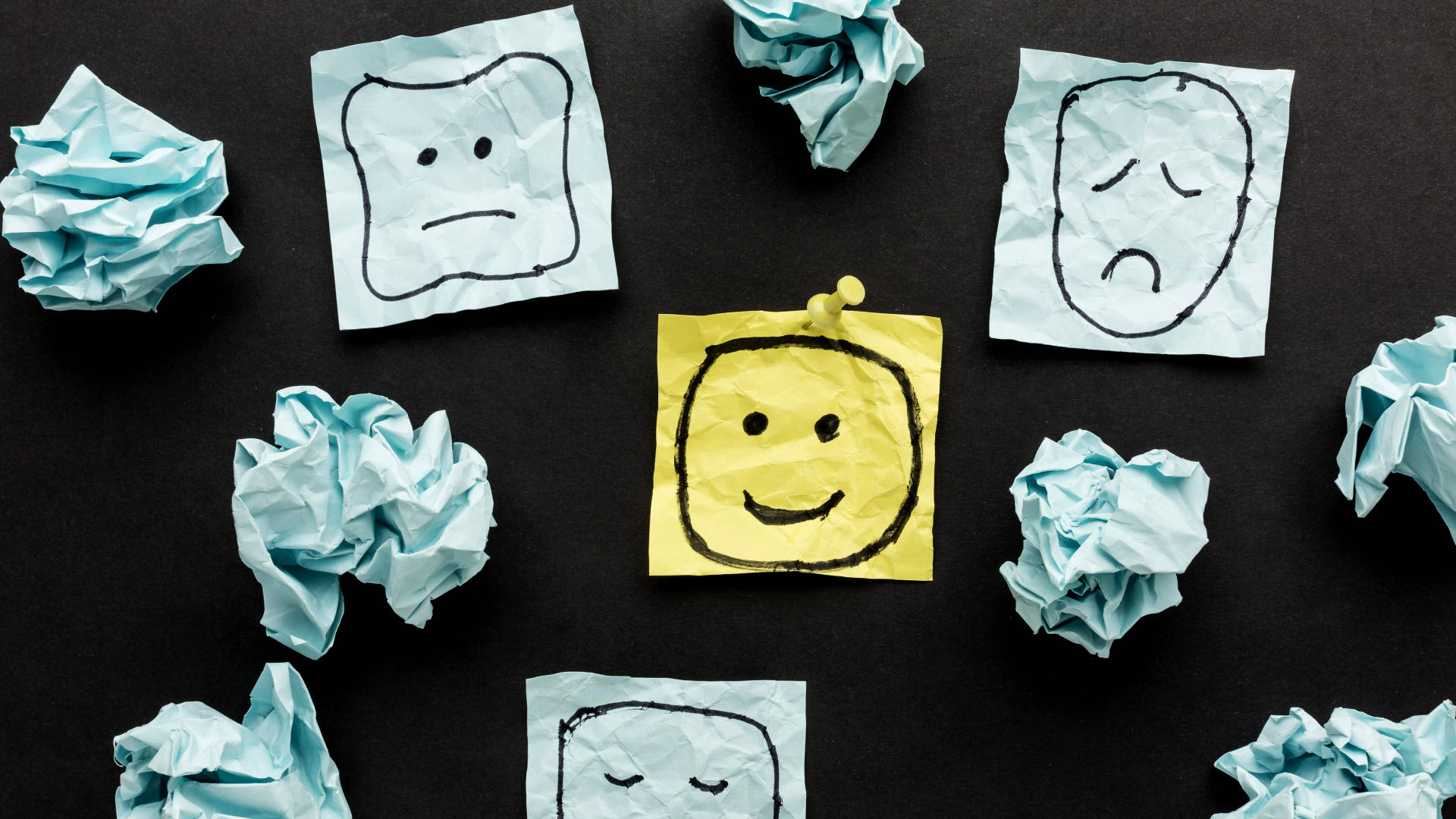 tanti post-it su una lavagna nero con faccine disegnate