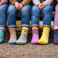 Bambini seduti con calzini colorati e spaiati