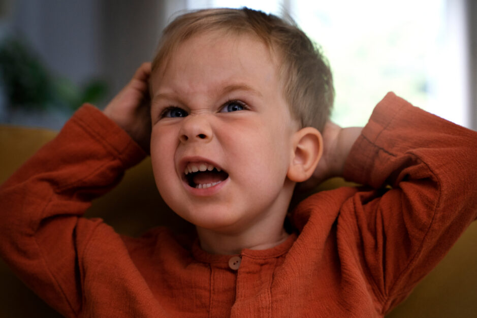 Volto di un bambino che fa una smorfia arrabbiato.