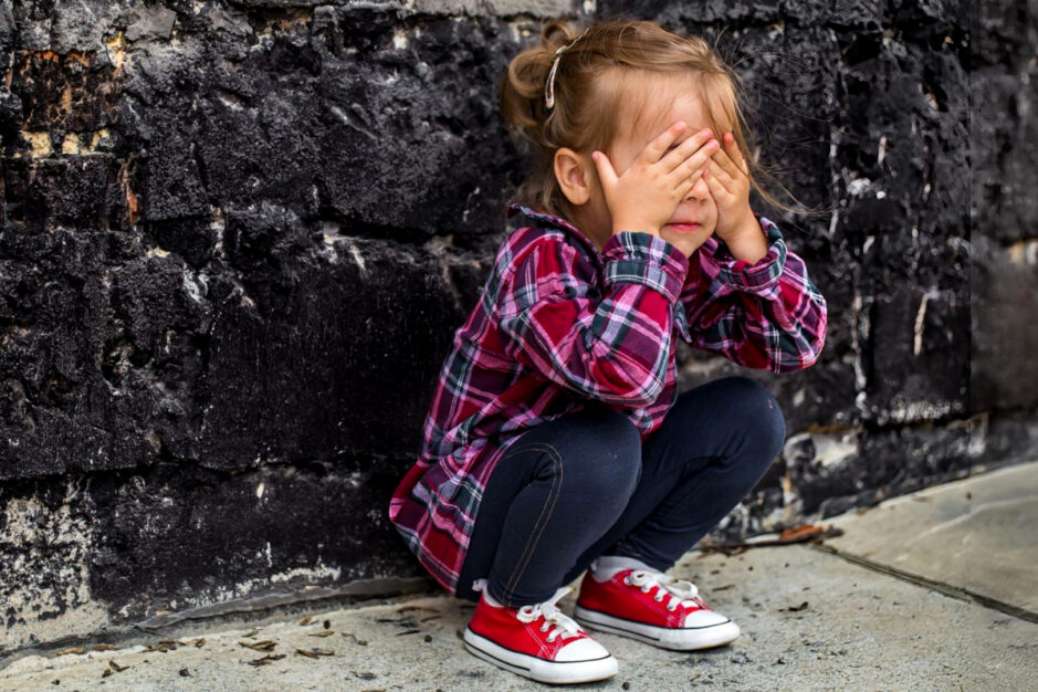 bimba che piange contro un muro