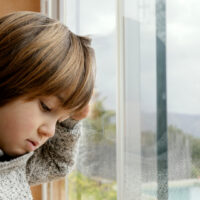 bambino triste alla finestra