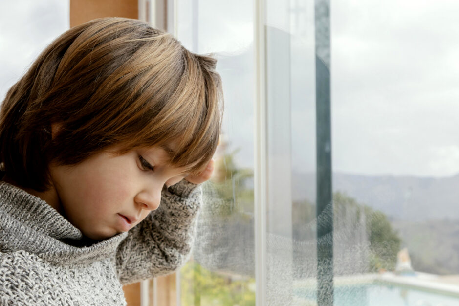 bambino triste alla finestra