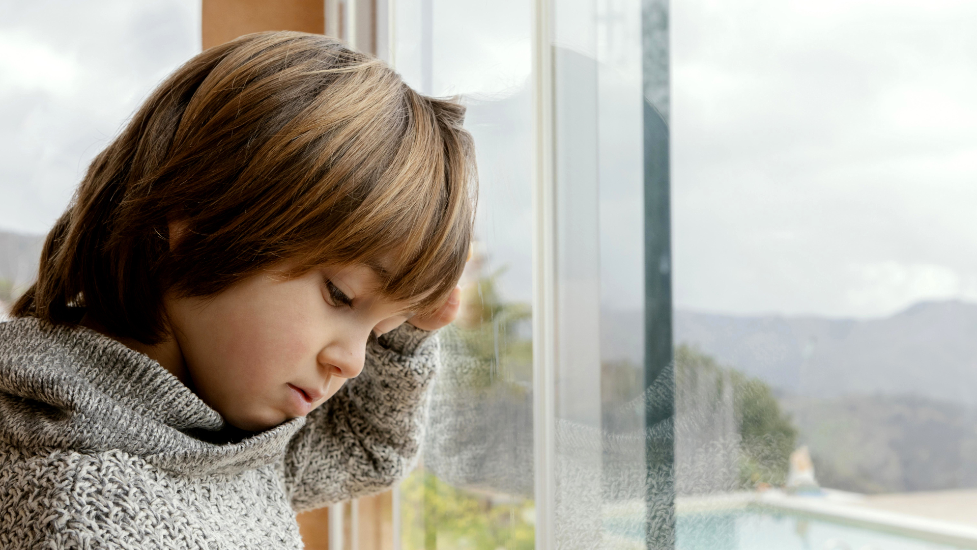 bambino triste alla finestra
