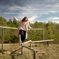 Donna che si bilancia su travi di legno