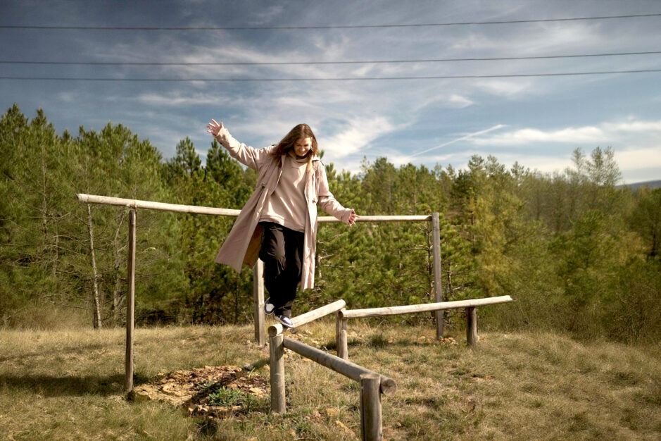 Donna che si bilancia su travi di legno