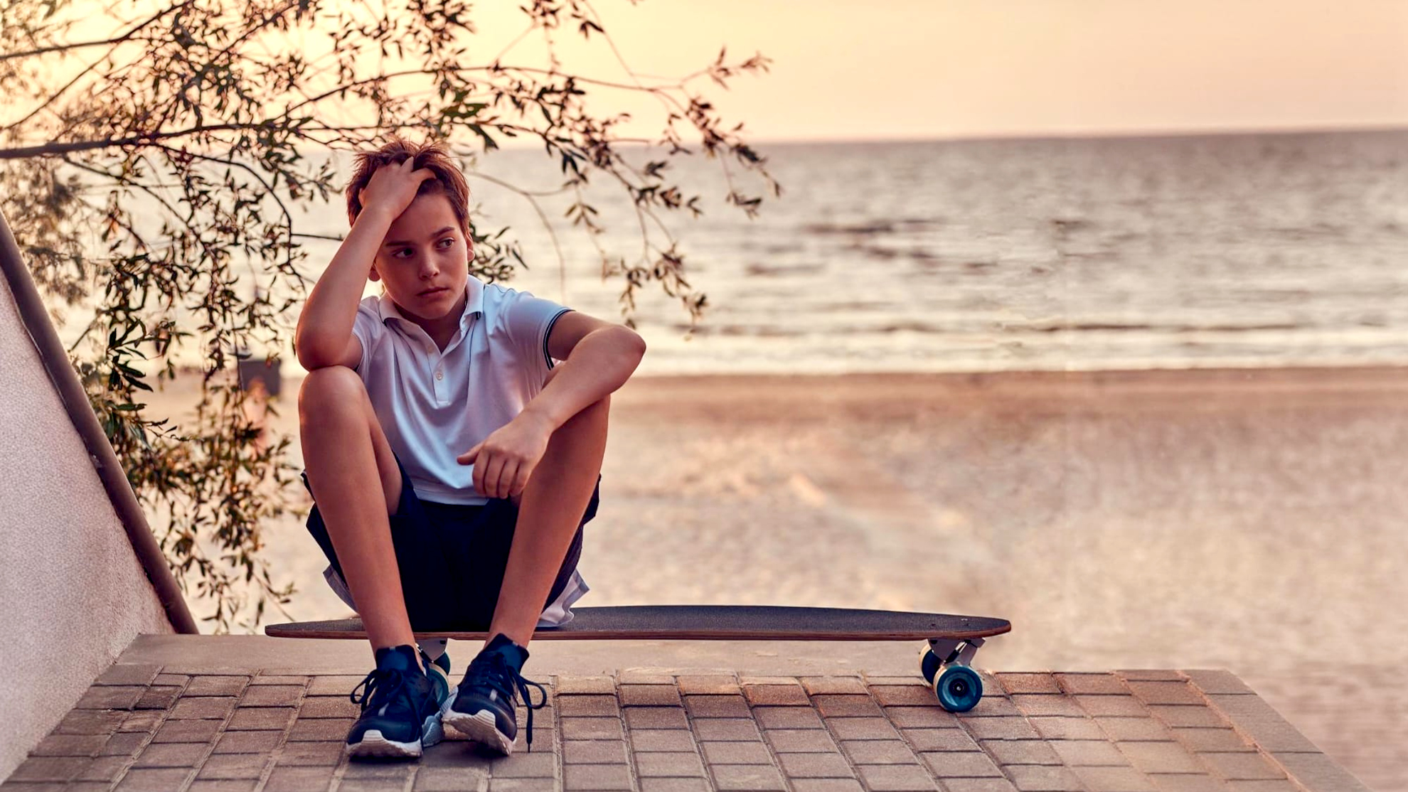 adolescente annoiato seduto su di uno skateboard