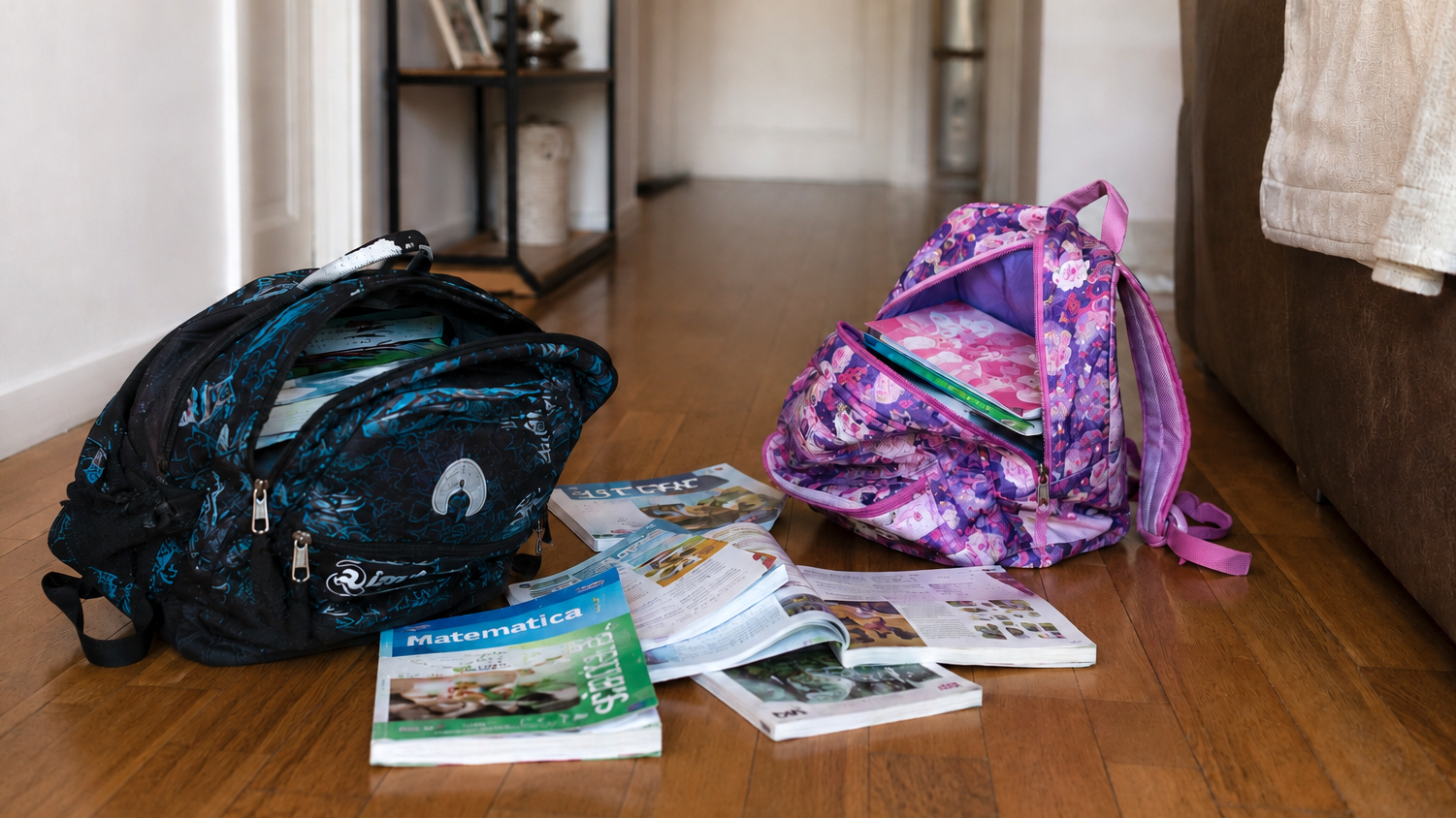 due zaini di scuola con alcuni libri di scuola lasciati sul pavimento di casa