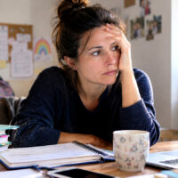 mamma al computer con sguardo ansioso e preoccupato
